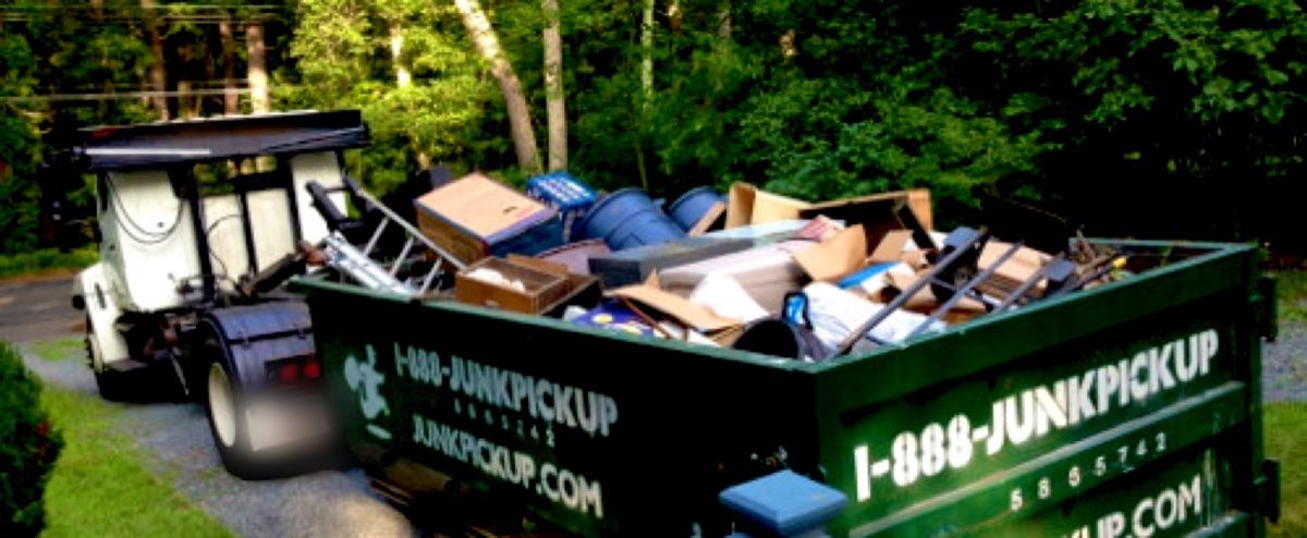 Full JunkPickup.com dumpster loaded with boxes, furniture and household junk