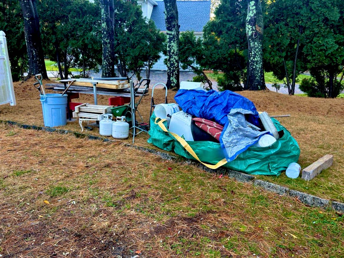 A filled junk bag and household items at the curb waiting for pickup