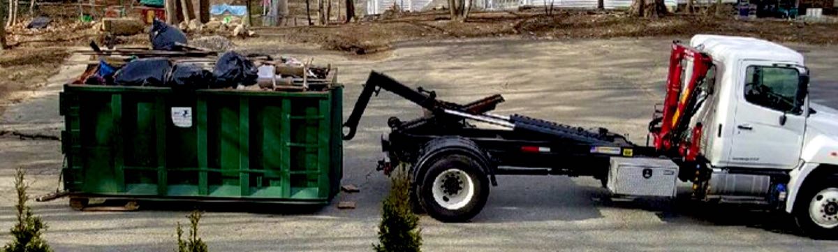 LPC Removal Service roll-off truck setting down a loaded JunkPickup.com dumpster
