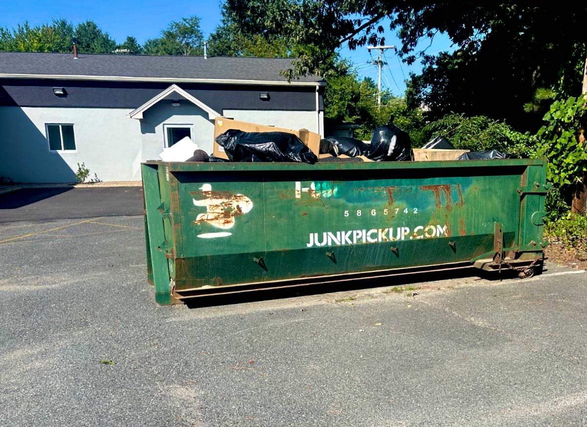 JunkPickup.com roll-off dumpster in a parking lot during a commercial build-out on South Street in Wrentham, MA
